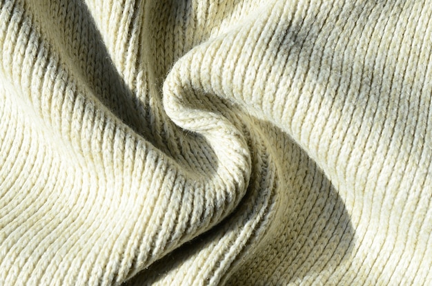 Texture de tissu d&#39;un pull tricoté jaune doux. Macro image de la structure des reliures en fils