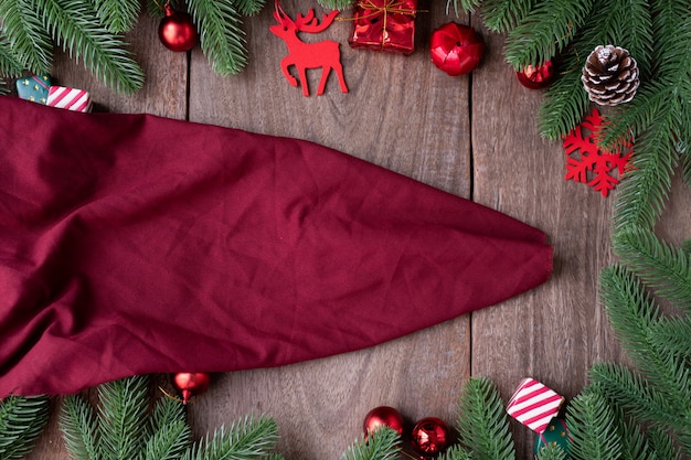 Texture de tissu rouge et décorations de Noël sur planche de bois.