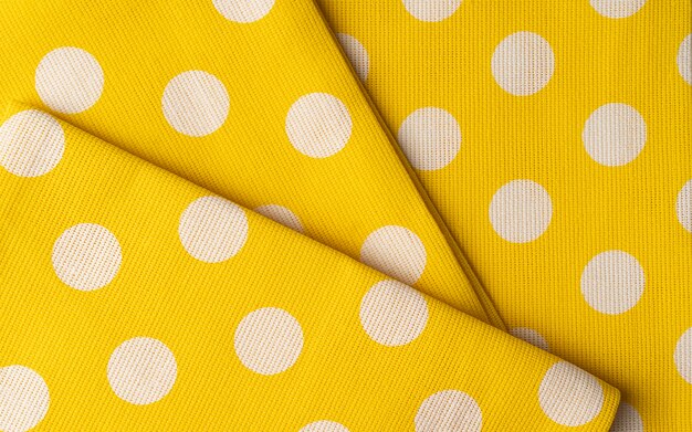 Texture de tissu de tissu de coton jaune. Fond textile à pois ou papier peint.