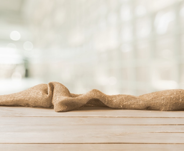 Texture de toile de jute sur table en bois sur fond flou