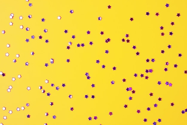 Texture de vacances colorées avec des confettis sur jaune