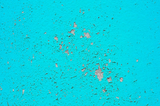 La texture de la vieille peinture bleue est ébréchée et fissurée au mur