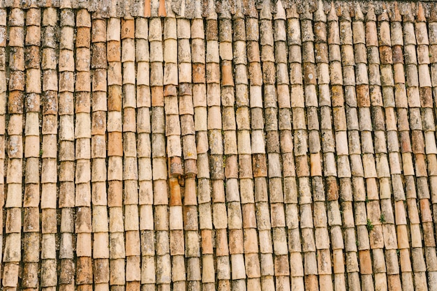 La texture des vieux bardeaux bruns sur le toit du bâtiment