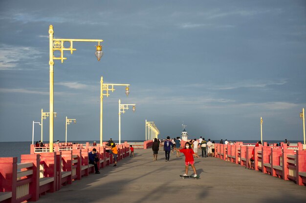 Les Thaïlandais voyageurs étrangers voyagent visitent se détendre et faire de l'exercice en jouant au skateboard sur le pont rouge de Saphan saranwithi à la plage de la baie de Prachuap le 6 septembre 2021 à Prachuap Khiri Khan Thaïlande