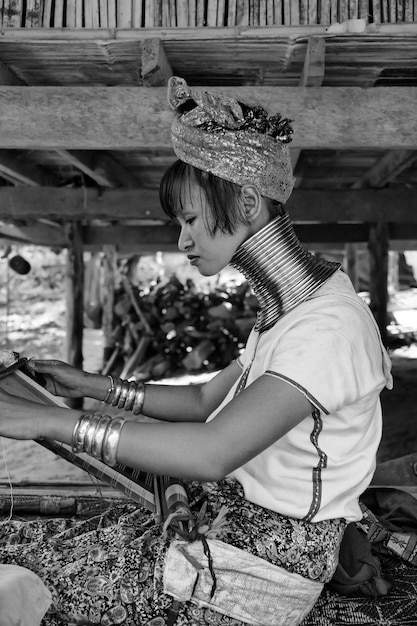 Photo thaïlande, chang mai, village de la tribu des collines karen long neck (kayan lahwi), femme long neck en costumes traditionnels. les femmes mettent des anneaux en laiton sur leur cou quand elles ont 5 ou 6 ans et augmentent l'engourdissement
