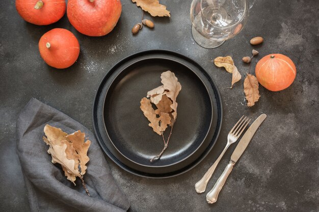 Thanksgiving Day ou Halloween place setting avec citrouille sur tableau noir. Vue de dessus.