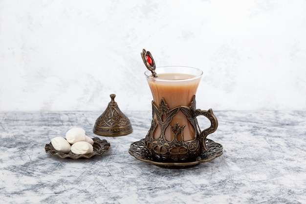 Thé Adrak ou thé au gingembre indien Masala chai avec lait et épices sur fond gris