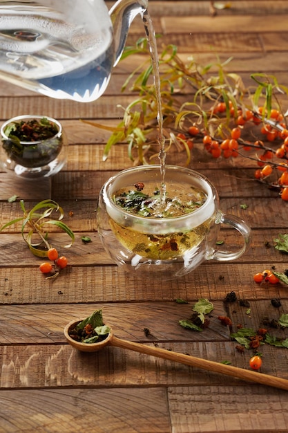 Thé d'argousier dans une tasse en verre sur un fond en bois