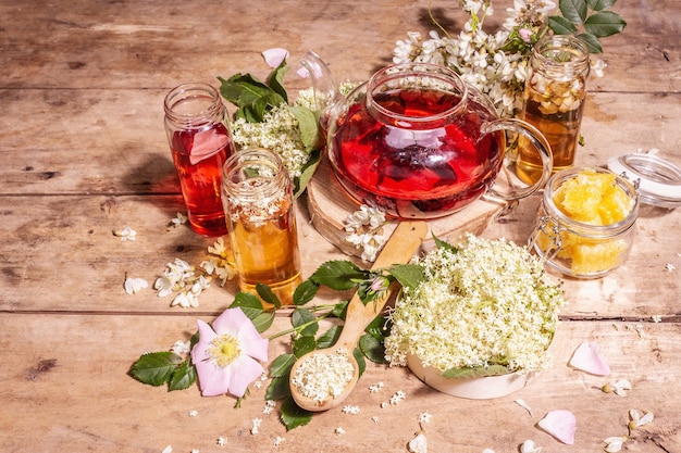 Thé assorti à base de fleurs. Sureau frais, églantier et acacia. Concept d'alimentation saine. Vieux fond de planches de bois, espace de copie