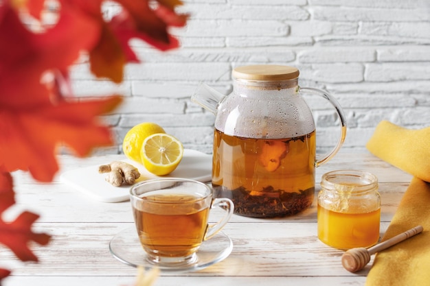 Thé au citron gingembre et miel sur table en bois blanc Médecine alternative