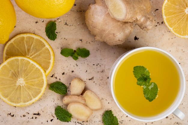 Thé au citron sicilien au gingembre et feuilles de menthe sur pierre de marbre blanc.