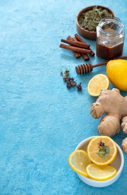 Thé au gingembre au citron dans une tasse en verre à fond bleu. Espace pour un texte.