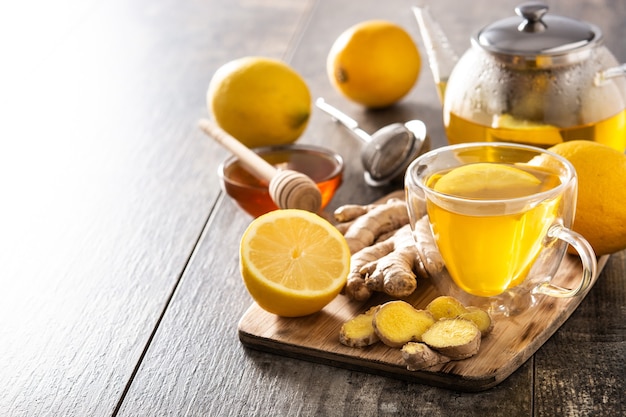 Thé au gingembre au citron et miel en verre de cristal sur table en bois