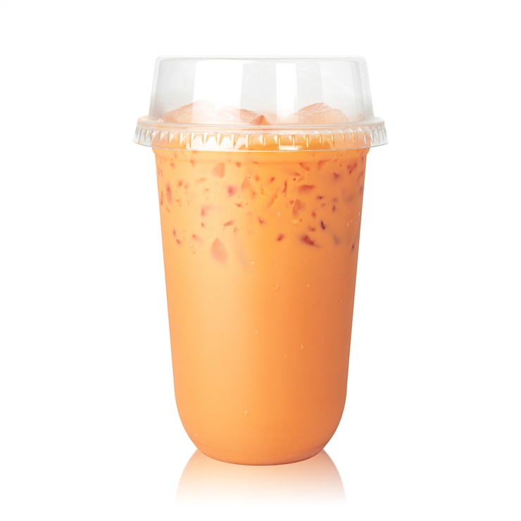 Photo thé au lait thaïlandais avec tasse isolé sur blanc.