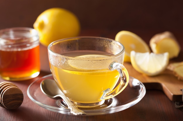 Thé au miel et au gingembre citron chaud dans une tasse en verre