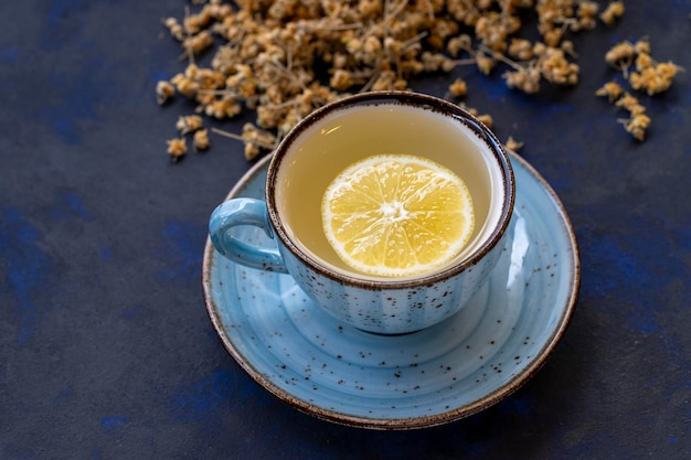 Thé au tilleul dans une tasse sur fond noir et bleu