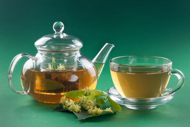 Thé au tilleul dans une théière et une tasse transparentes