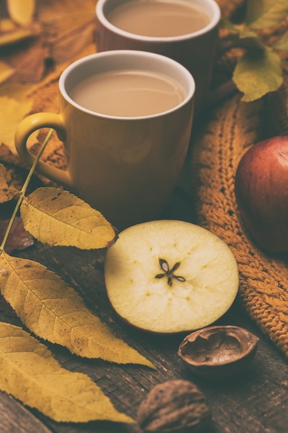 Thé d'automne confortable - thé avec du lait, des pommes, des noix et un pull chaud