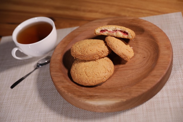 le thé aux baies et une assiette décorative en bois sont très beaux pour les légumes et les biscuits