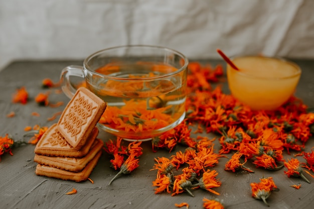 Thé aux fleurs de calendula et biscuits. Verre transparent