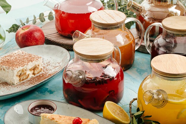 Thé aux fruits assortis dans des pots en verre sur le fond bleu