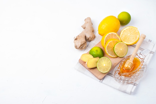 thé aux herbes, citron et gingembre sur fond blanc et miel