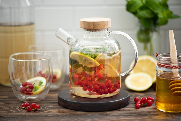 Photo thé aux petits fruits avec groseilles rouges, citron, menthe et miel