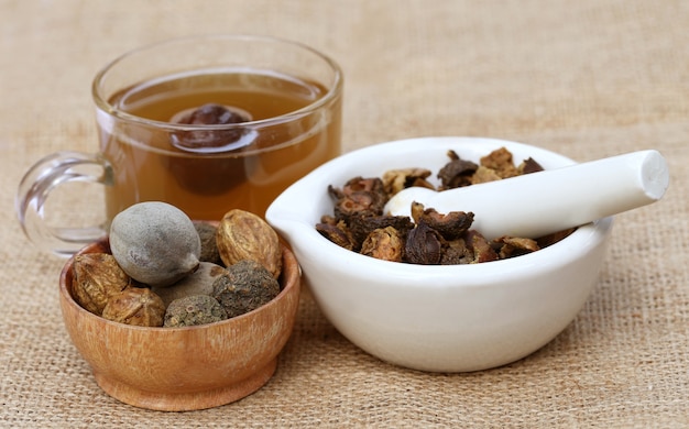 Thé à base de Triphala, une combinaison de fruits ayurvédiques avec mortier et pilon