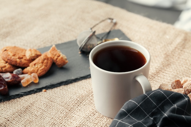 Thé avec des biscuits sur fond d'un sac