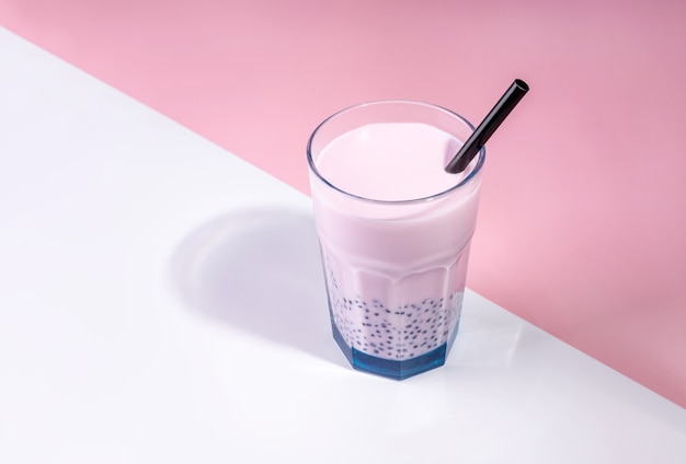 Thé avec des bulles de lait aux fraises dans un grand verre avec une paille