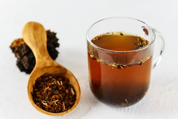 Thé Chaga dans une tasse sur une table lumineuse