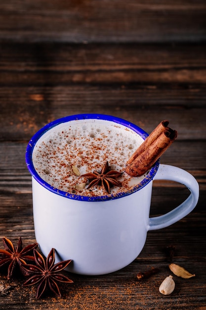 Thé chai masala chaud aux épices sur fond de bois