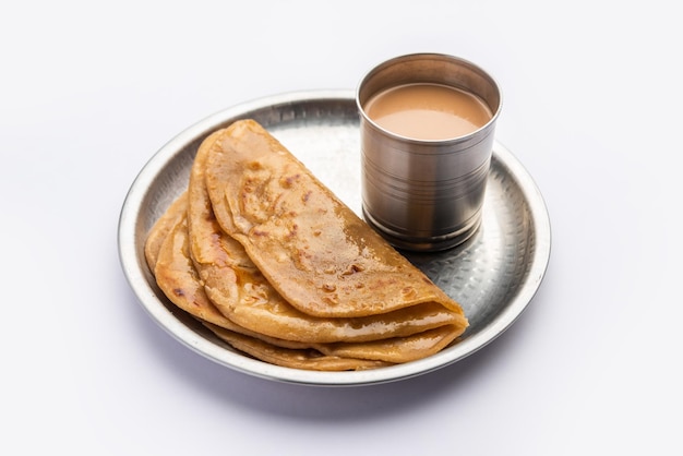 Le thé chaud Chai Paratha servi avec du pain plat est un repas traditionnel simple de l'Inde et du Pakistan