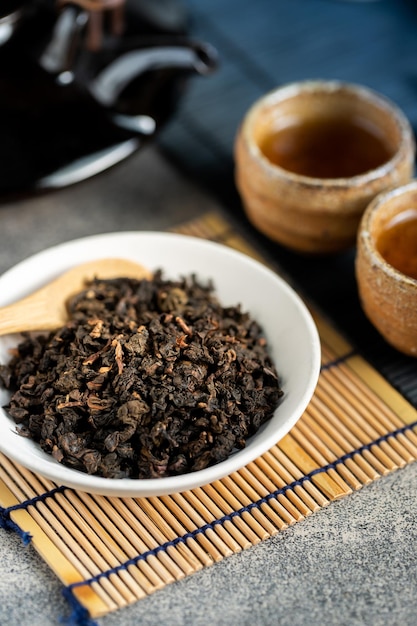 Thé chaud dans une théière en verre et une tasse avec de la vapeur