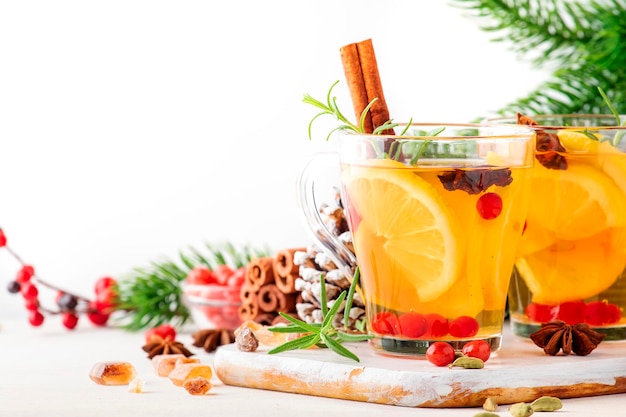 Thé chaud d'hiver avec des herbes et des épices de canneberges au citron dans l'espace de copie de fond blanc de table de Noël ou du Nouvel An