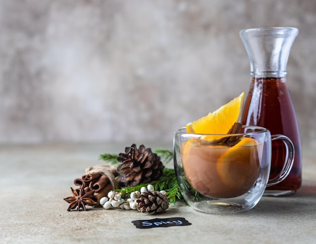 Thé chaud ou punch à l'orange et aux épices dans une tasse en verre Boisson chaude épicée Boisson chaude de saison