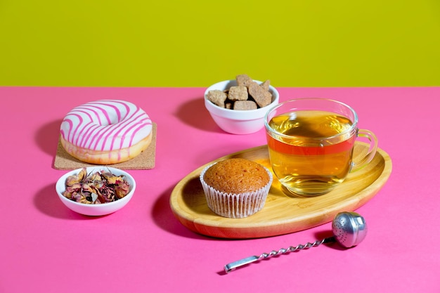 Thé dans une tasse avec dessert sur un fond de couleur vive