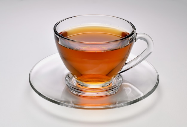 Thé dans une tasse en verre transparent sur fond blanc