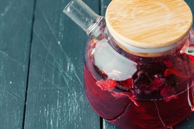 Thé Earl Grey dans une théière en verre sur une plaque de bois se bouchent