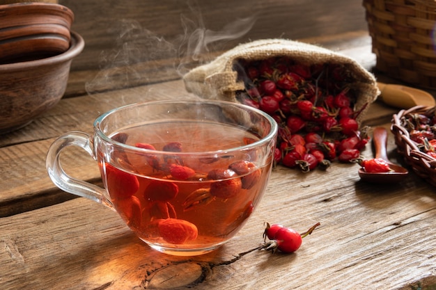 Thé d'églantier sur fond de bois avec des fruits rouges