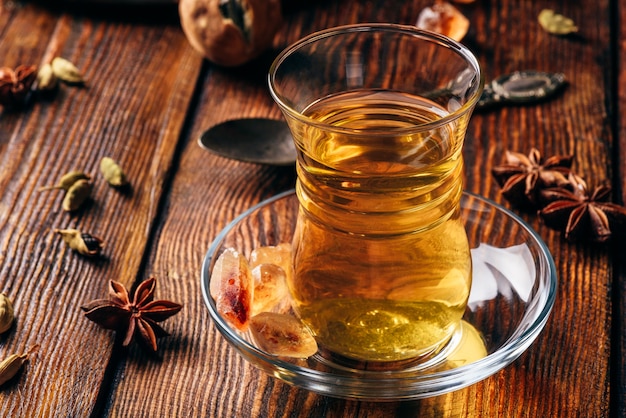 Thé épicé à l'anis étoilé, cardamome et citron vert séché en verre armudu sur surface en bois