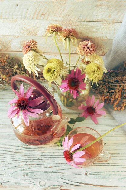 Thé de fleurs fraîches d'échinacée et de menthe, sur une table en bois, herbes médicinales