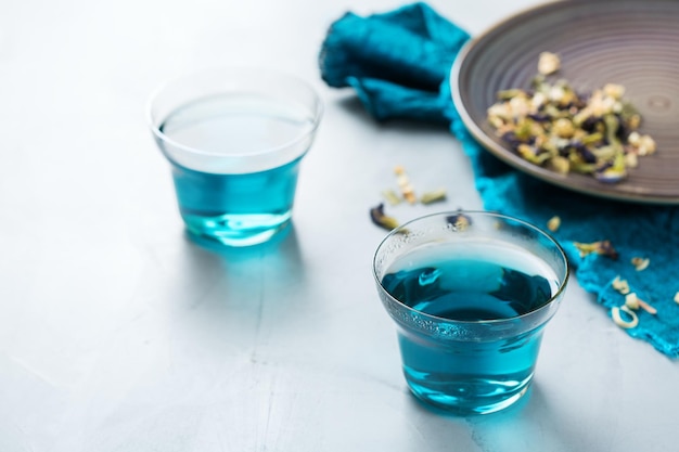 Thé de fleurs de pois papillon bleu dans un verre sur la table