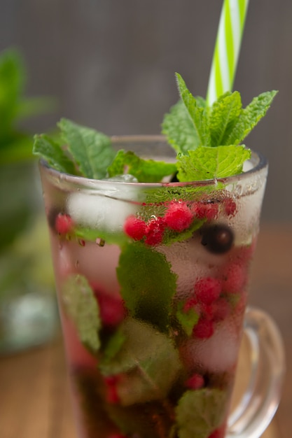 Thé de fruits frais aux fraises dans une coupe en verre, boisson de thé de fruits d&#39;été, fond en bois.