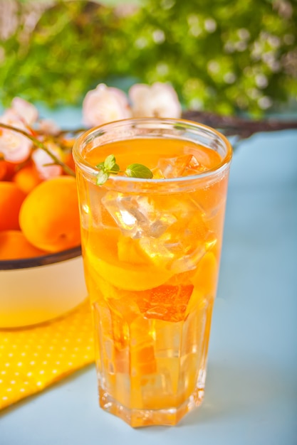 Thé glacé à l'abricot fait maison avec des glaçons et de la menthe