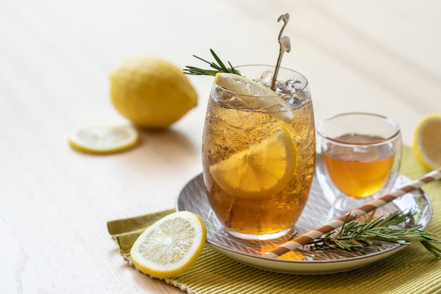 Thé glacé au citron et au miel sur une assiette, boisson estivale rafraîchissante.