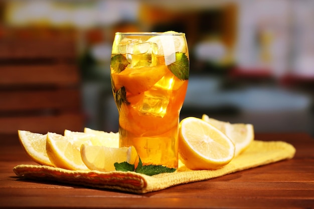 Thé glacé au citron et à la menthe sur une table en bois à l'extérieur