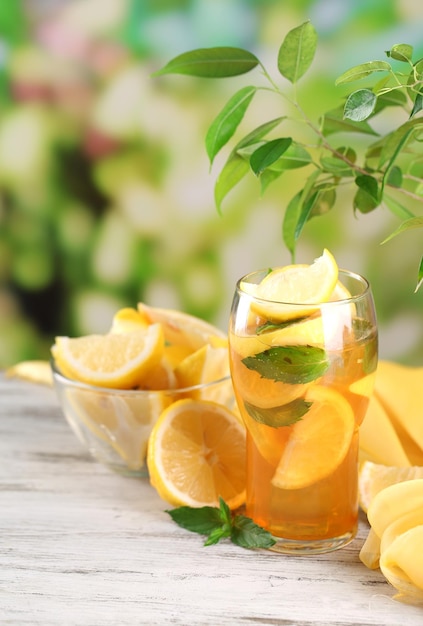 Thé glacé au citron et à la menthe sur une table en bois à l'extérieur