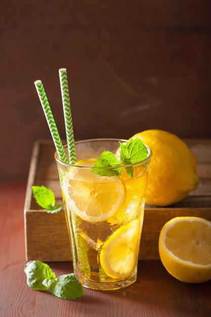 Thé glacé au citron et à la menthe sur une table rustique sombre