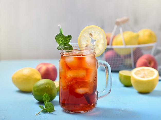 Thé glacé aux citrons, limes et menthe avec des glaçons, boisson rafraîchissante d'été